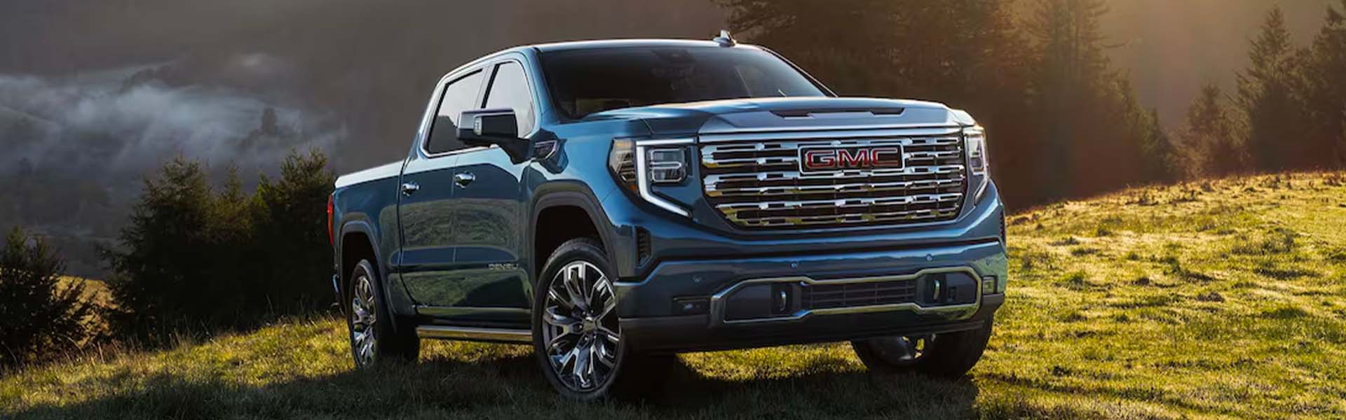 Front side view of GMC Sierra 1500 on a grassy hill on stormy weather