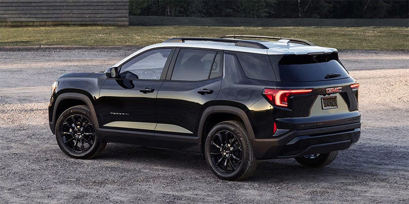 Rear side view of 2025 GMC Terrain on a gravel road